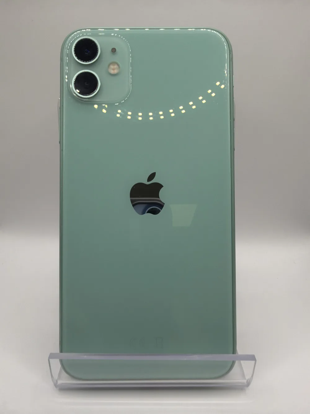 iPhone 11 vert d'eau, vu de dos, double capteur photo, posé sur un support transparent