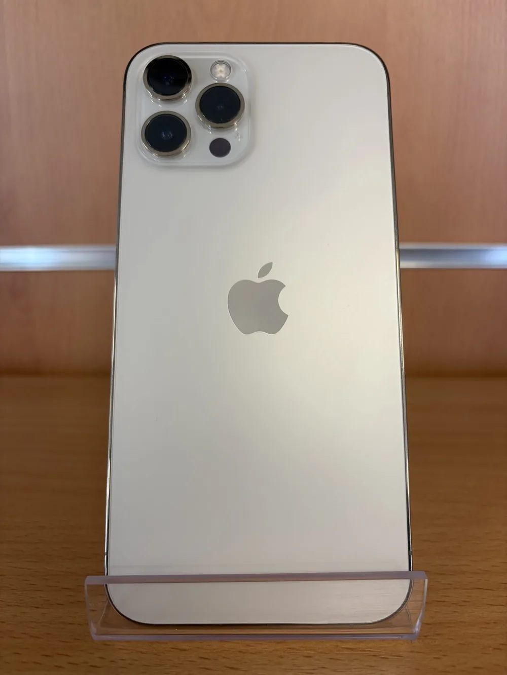 iPhone 12 Pro Max argent, vu de dos, triple capteur photo, posé sur un support transparent