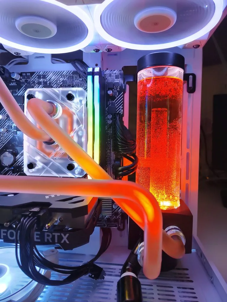 Gros plan sur le réservoir et le waterblock processeur d’une boucle au liquide orange